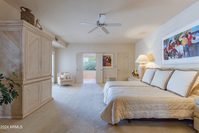 bedroom with ensuite bath, ceiling fan, and light carpet