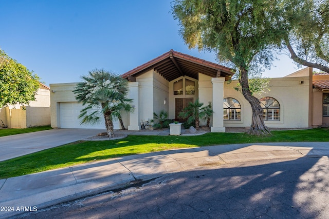 view of front of house with a garage and a front lawn