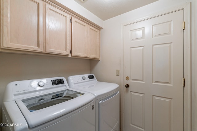 laundry area with cabinets, independent washer and dryer, and a textured ceiling