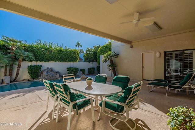 view of patio with a fenced in pool and ceiling fan