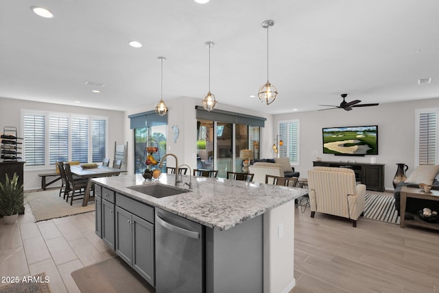 kitchen with dishwasher, sink, hanging light fixtures, a kitchen island with sink, and gray cabinetry