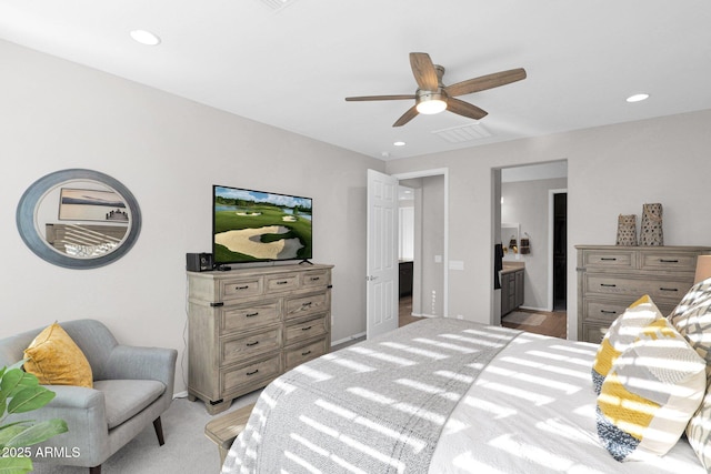 bedroom with light carpet, ensuite bath, and ceiling fan