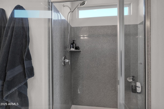 bathroom featuring a tile shower and a healthy amount of sunlight