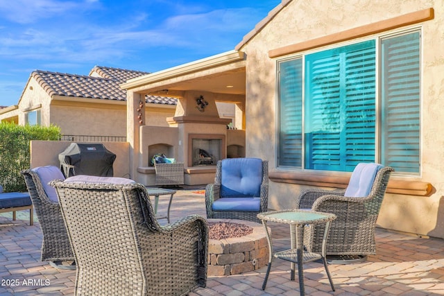 view of patio / terrace featuring exterior fireplace and a grill