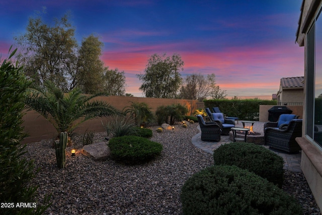 yard at dusk featuring an outdoor living space and a patio