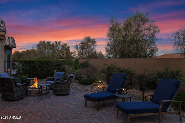 patio terrace at dusk featuring an outdoor fire pit