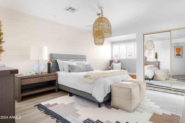 bedroom with light hardwood / wood-style flooring and a closet