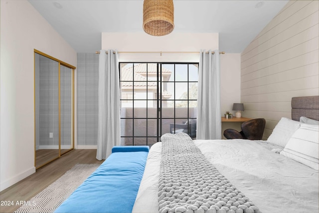 bedroom featuring hardwood / wood-style flooring, a closet, and lofted ceiling