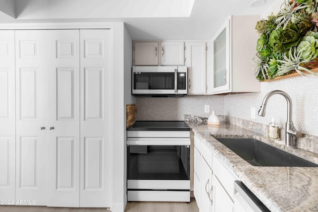 kitchen featuring white cabinets, sink, appliances with stainless steel finishes, and light hardwood / wood-style flooring