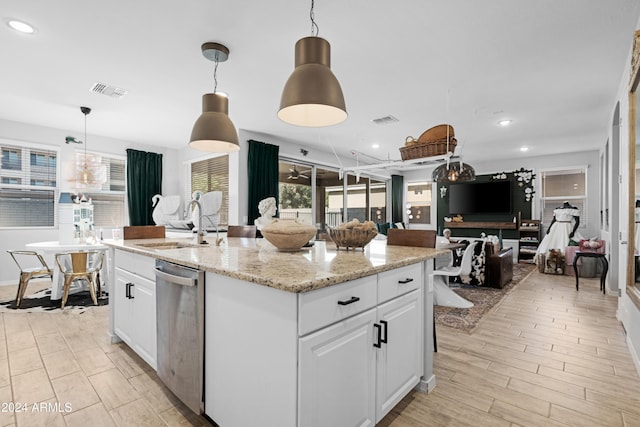 kitchen featuring white cabinets, decorative light fixtures, dishwasher, and a kitchen island with sink