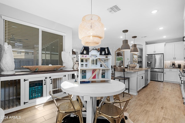 dining area featuring sink and light hardwood / wood-style floors