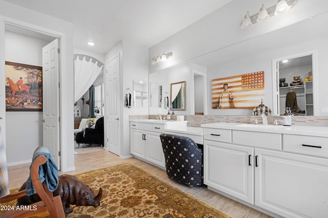 bathroom with vanity, wood-type flooring, and backsplash