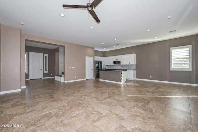 unfurnished living room featuring sink and ceiling fan