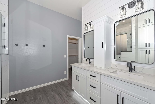 bathroom with wood-type flooring, vanity, and walk in shower