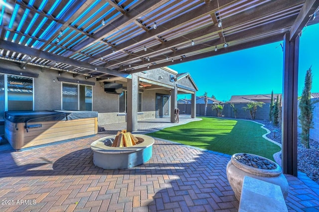 view of patio featuring a hot tub, a pergola, and an outdoor fire pit