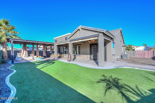 rear view of property featuring ceiling fan, a yard, a patio area, and central air condition unit