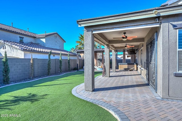 view of yard featuring ceiling fan and a patio