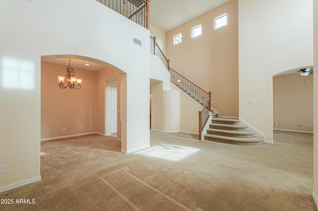 unfurnished living room with carpet, visible vents, and stairs