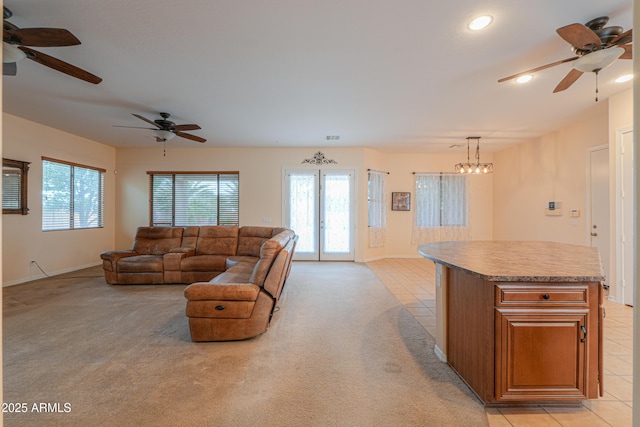 living room with light carpet, a healthy amount of sunlight, light tile patterned floors, and visible vents