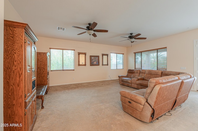 living room featuring a healthy amount of sunlight, baseboards, visible vents, and light colored carpet