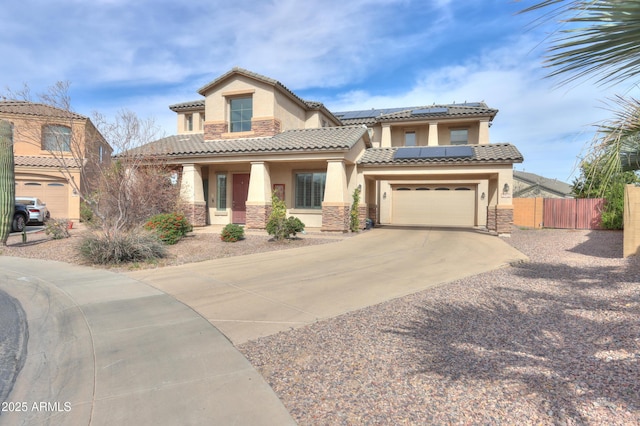 mediterranean / spanish-style house featuring solar panels, stucco siding, concrete driveway, fence, and stone siding