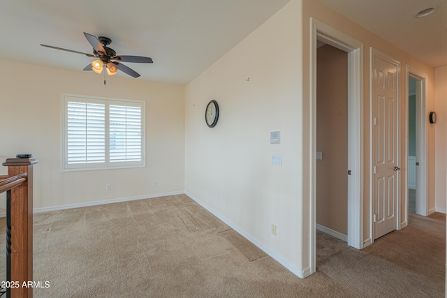 carpeted empty room with ceiling fan and baseboards