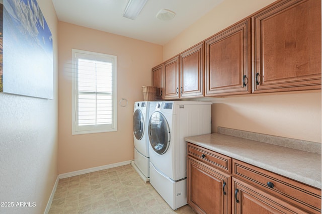 laundry room featuring light floors, baseboards, cabinet space, and washing machine and clothes dryer