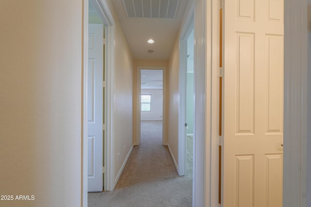 hallway featuring carpet, visible vents, and baseboards