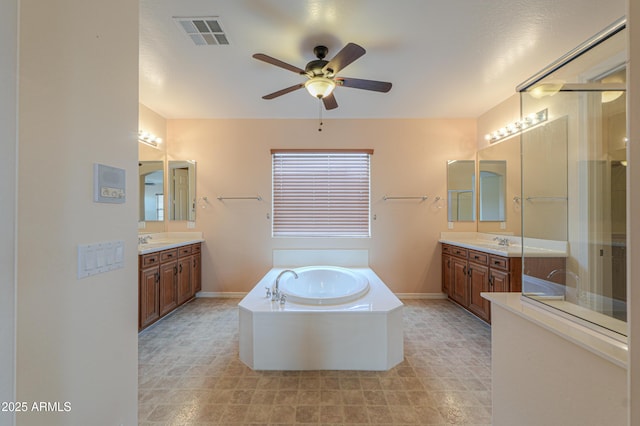 full bathroom with two vanities, visible vents, a sink, and a garden tub