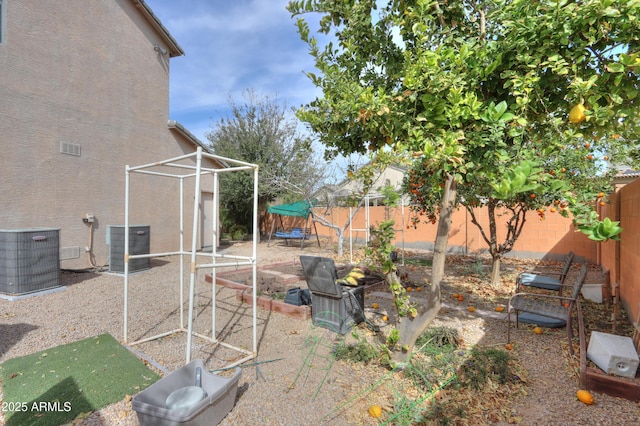 view of yard with central AC, a trampoline, and a fenced backyard