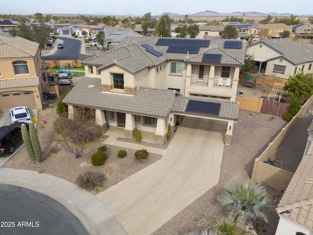 view of front of property featuring a fenced backyard, a tiled roof, driveway, a residential view, and stucco siding