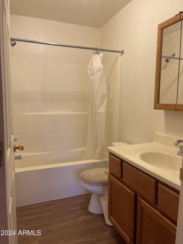 full bathroom with wood-type flooring, vanity, shower / tub combo, and toilet