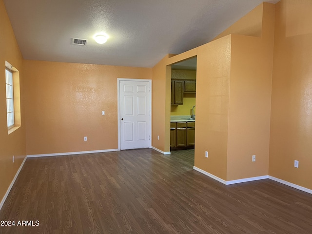 empty room featuring a textured ceiling and dark hardwood / wood-style flooring