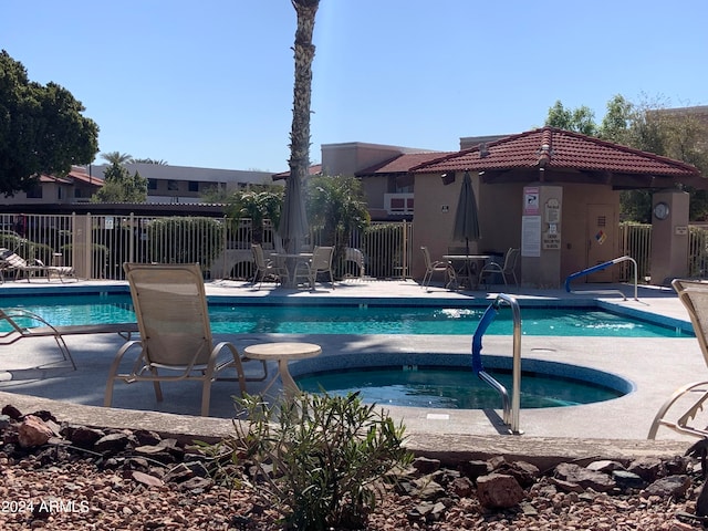 view of swimming pool featuring a community hot tub and a patio