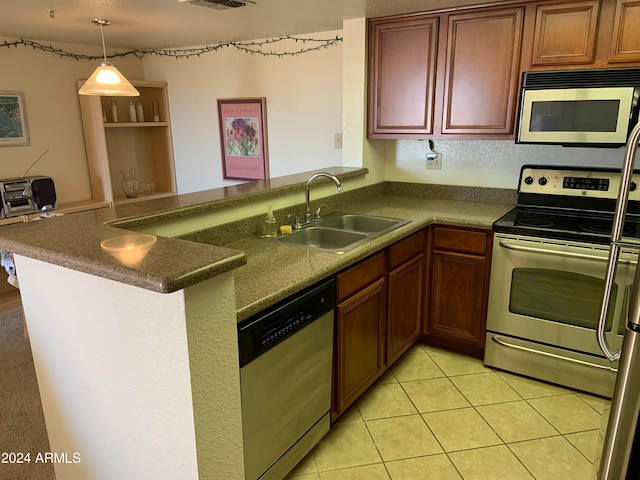 kitchen with kitchen peninsula, sink, light tile patterned floors, appliances with stainless steel finishes, and decorative light fixtures