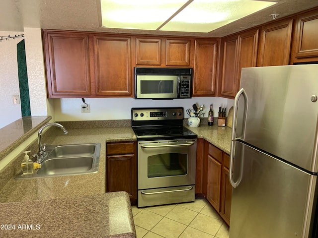 kitchen featuring light tile patterned flooring, sink, and appliances with stainless steel finishes