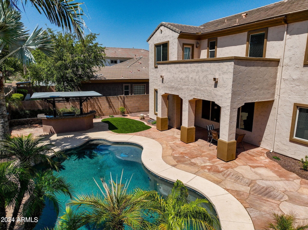 view of swimming pool featuring a bar and a patio area