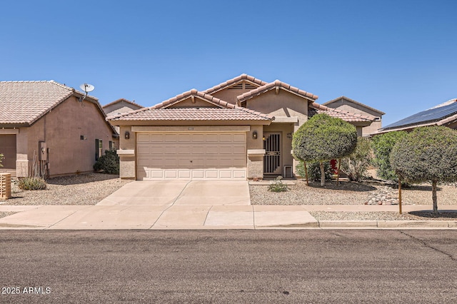 view of front facade with a tiled roof, stucco siding, driveway, and a garage