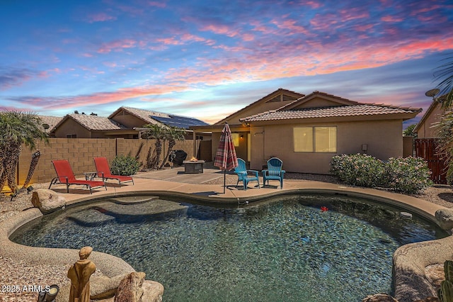exterior space with a fenced in pool, a patio area, stucco siding, a tile roof, and a fenced backyard