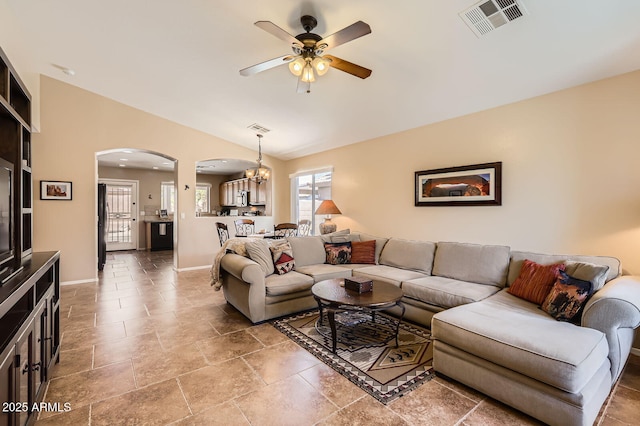 living room featuring ceiling fan with notable chandelier, visible vents, vaulted ceiling, arched walkways, and plenty of natural light