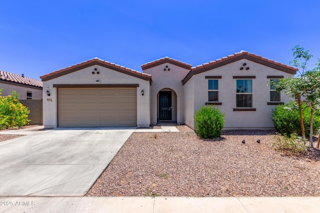 2347 W Sunland Ave, Phoenix, AZ 85041 - mediterranean / spanish-style house with a tiled roof, stucco siding, a garage, and concrete driveway