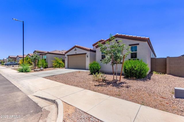 2347 W Sunland Ave, Phoenix, AZ 85041 - mediterranean / spanish-style house featuring concrete driveway, a tile roof, stucco siding, and a garage