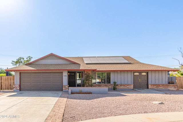 single story home with solar panels and a garage