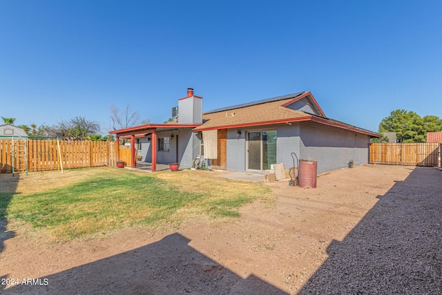 rear view of house with a patio and a yard