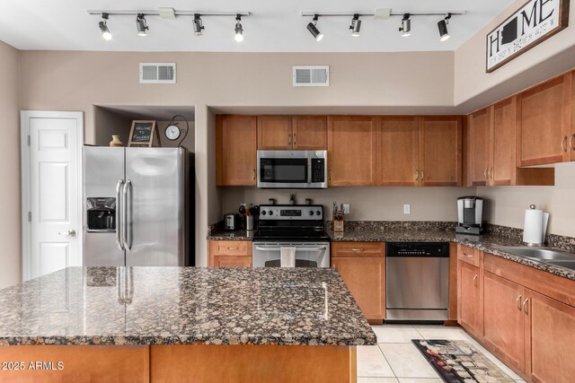 1920 E Bell Rd Unit 1189, Phoenix, AZ 85022 - kitchen featuring stainless steel appliances, a center island, brown cabinetry, and light tile patterned flooring