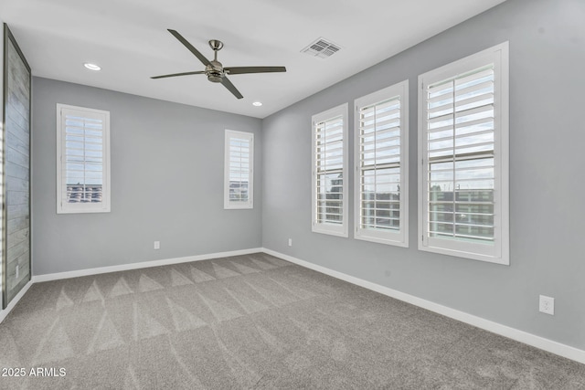 empty room with baseboards, visible vents, ceiling fan, and carpet flooring