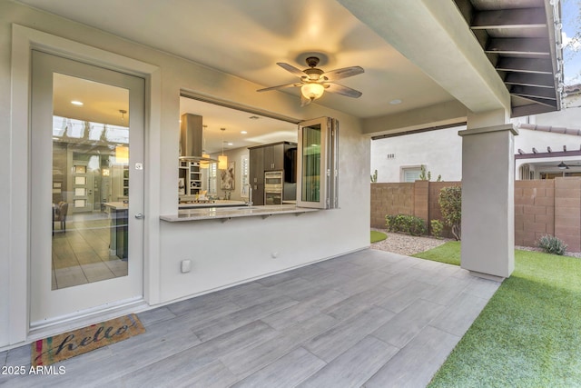 view of patio / terrace featuring fence and a ceiling fan