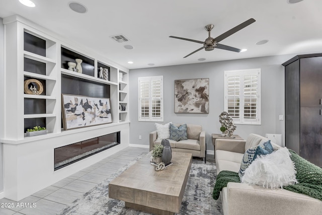 living area featuring visible vents, baseboards, a glass covered fireplace, ceiling fan, and recessed lighting