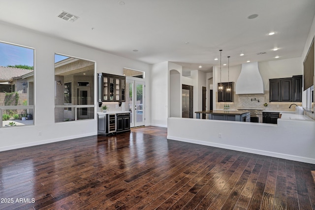 10310 N 135th Way, Scottsdale, AZ 85259 - unfurnished living room featuring dark wood-style floors, healthy amount of natural light, recessed lighting, a dry bar, and beverage cooler