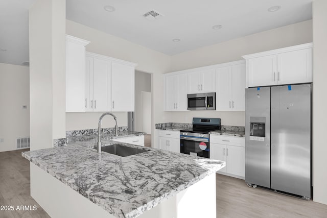 kitchen featuring white cabinetry, kitchen peninsula, sink, and appliances with stainless steel finishes